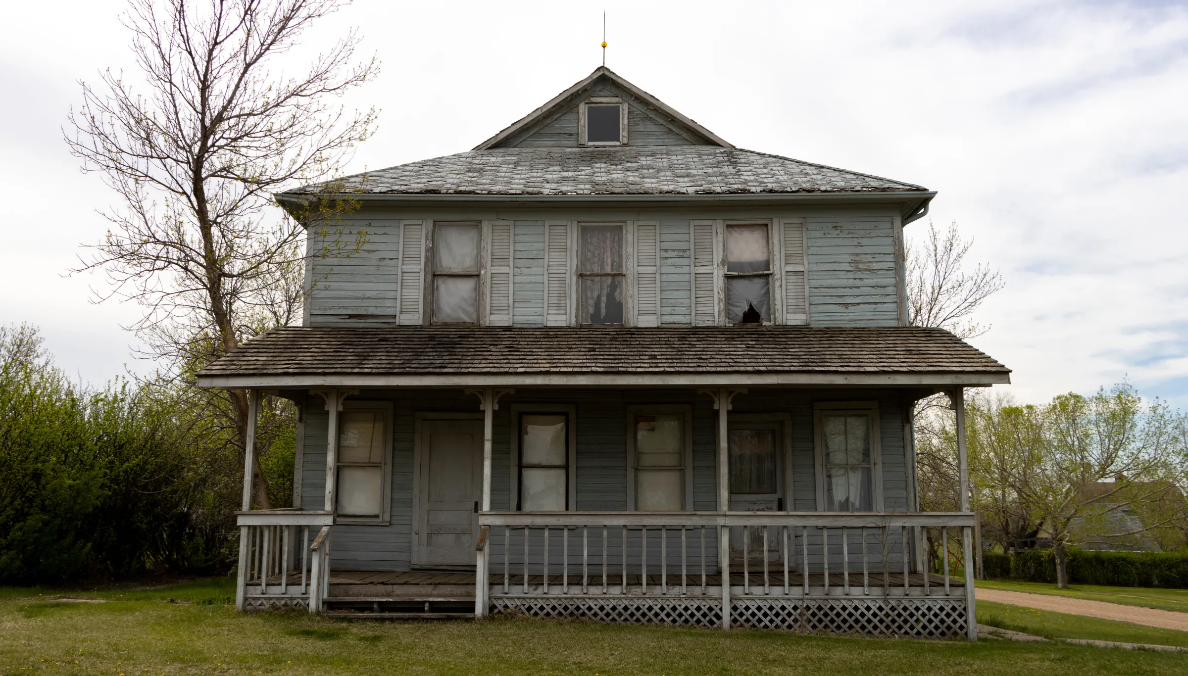 Old abandoned residential house in Dallas TX before full structure demolition showing deteriorated exterior and unsafe condition