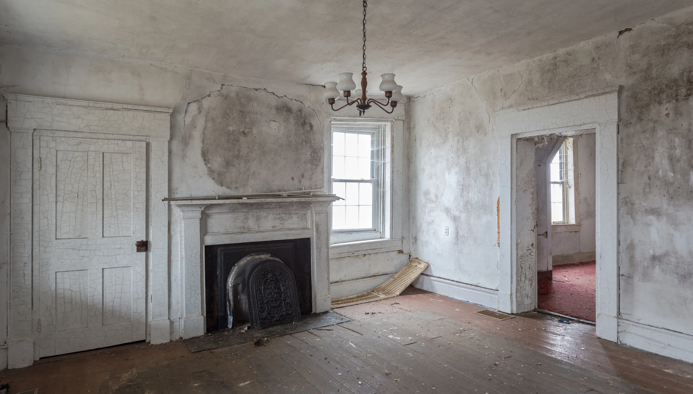 Old damaged interior in Dallas TX before demolition showing cracked walls peeling paint and outdated structure