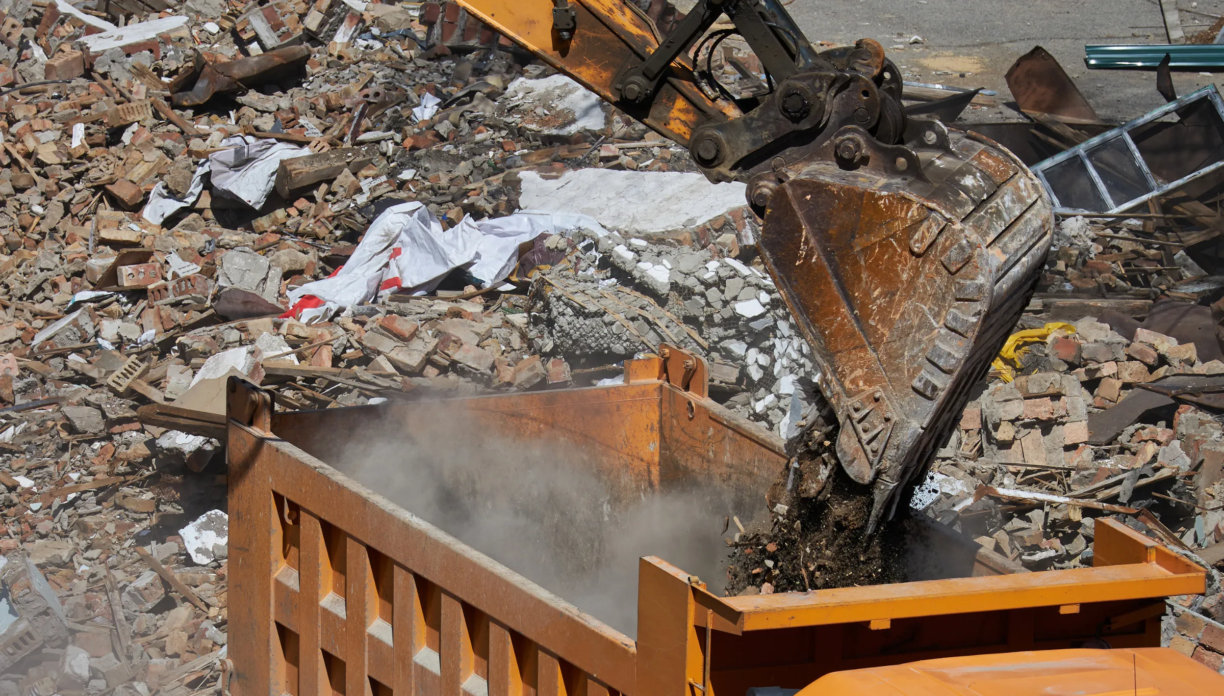Debris removal and hauling services in Dallas TX loading construction waste and rubble into dumpster for disposal