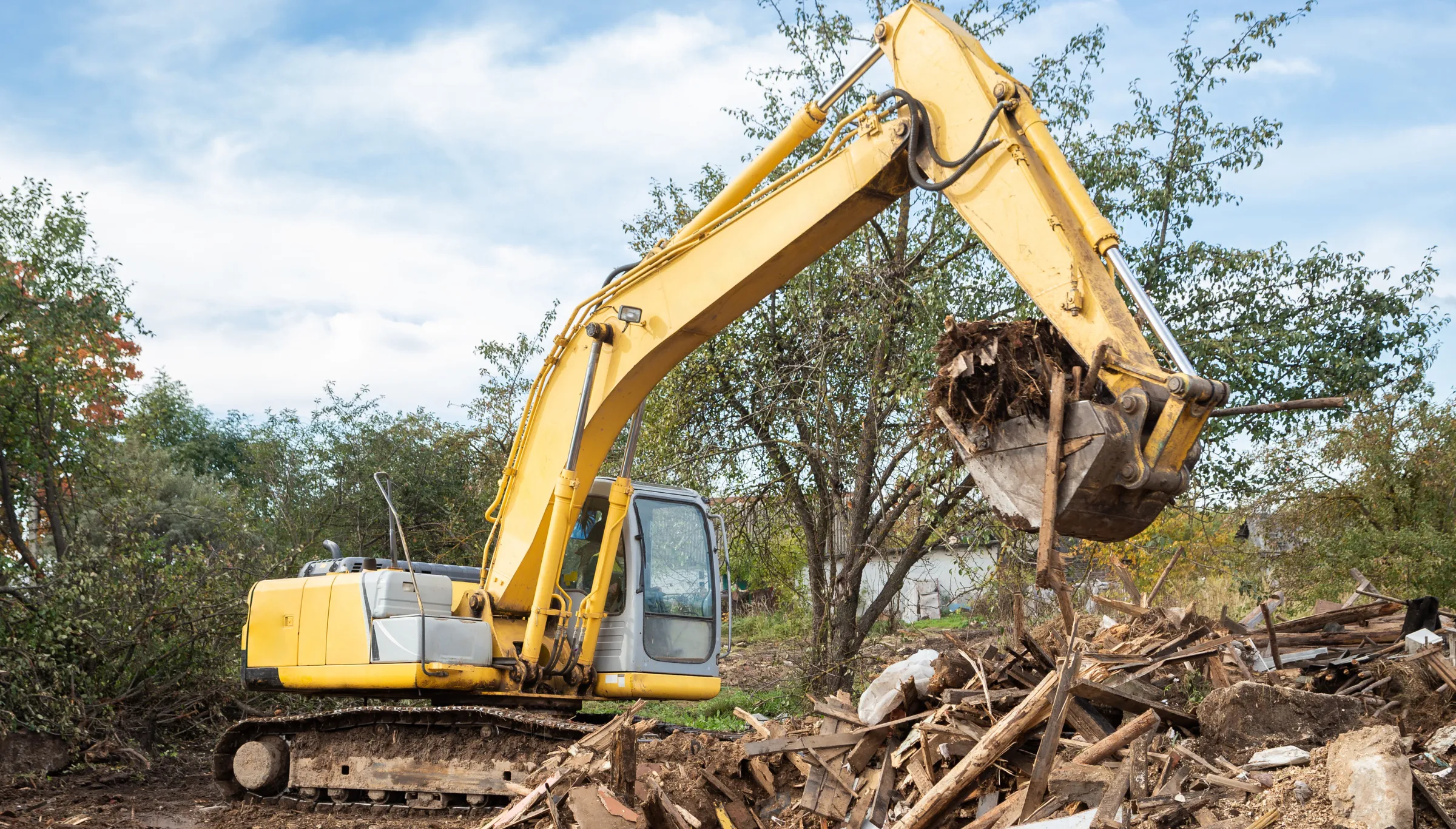 Debris hauling in Dallas TX using excavator to remove wood construction debris and site waste during cleanup process