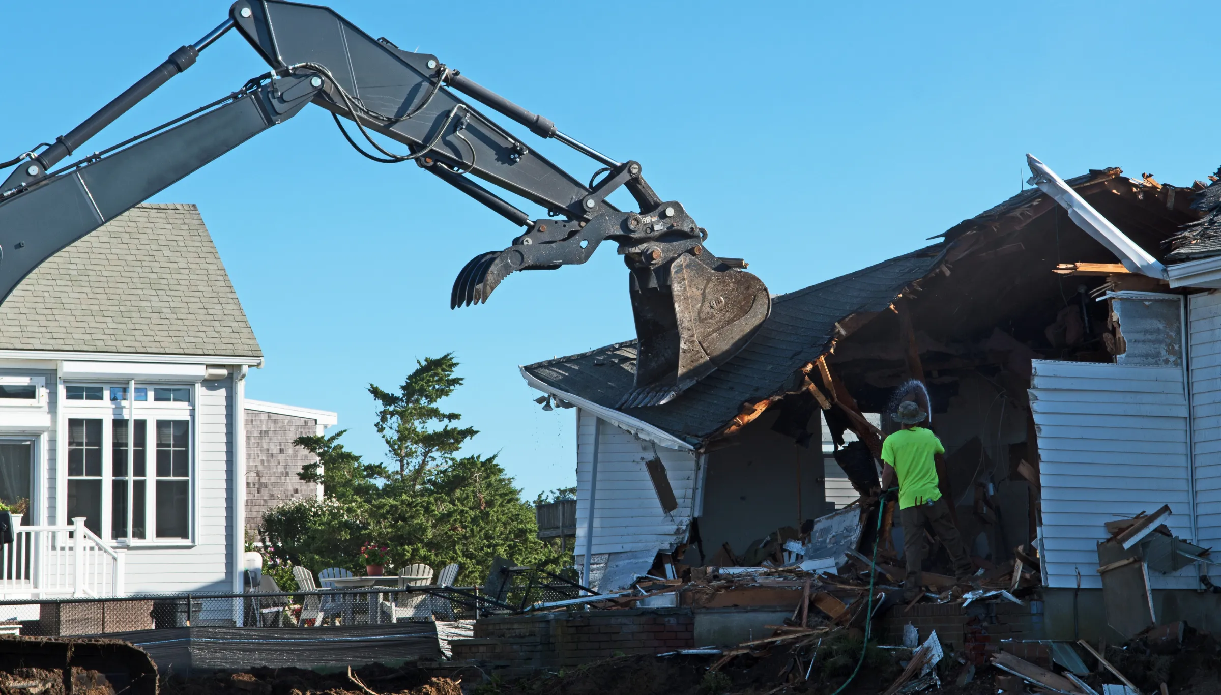 Excavator tearing through a roof during a full structure house demolition project in Dallas, TX
