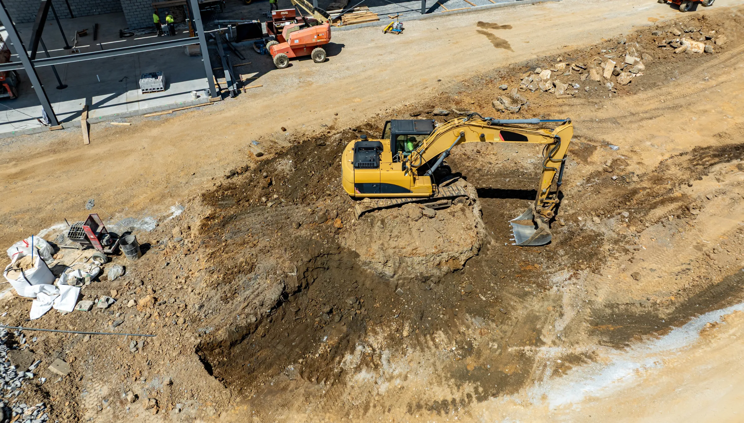 Excavator grading land during site preparation in Dallas TX leveling soil and preparing property for construction project