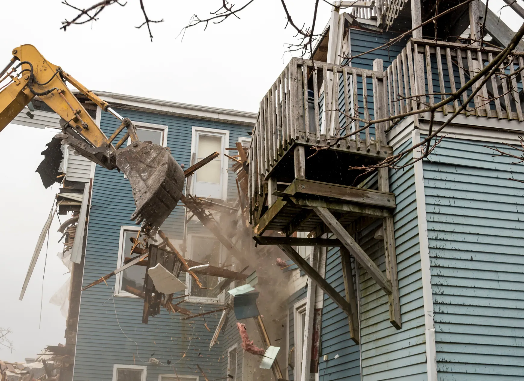 Heavy equipment performing residential demolition on a house in Dallas, TX